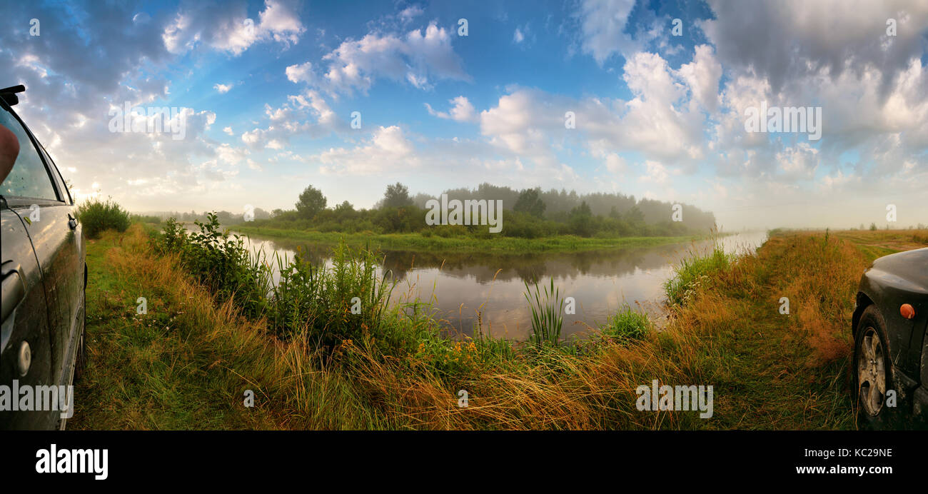 Volle 180 Grad Panorama schöne Sommer morgen Natur mit Gras und den Fluss. Sommer misty morning Fluss Weitwinkel Panorama. Auto Seiten Stockfoto