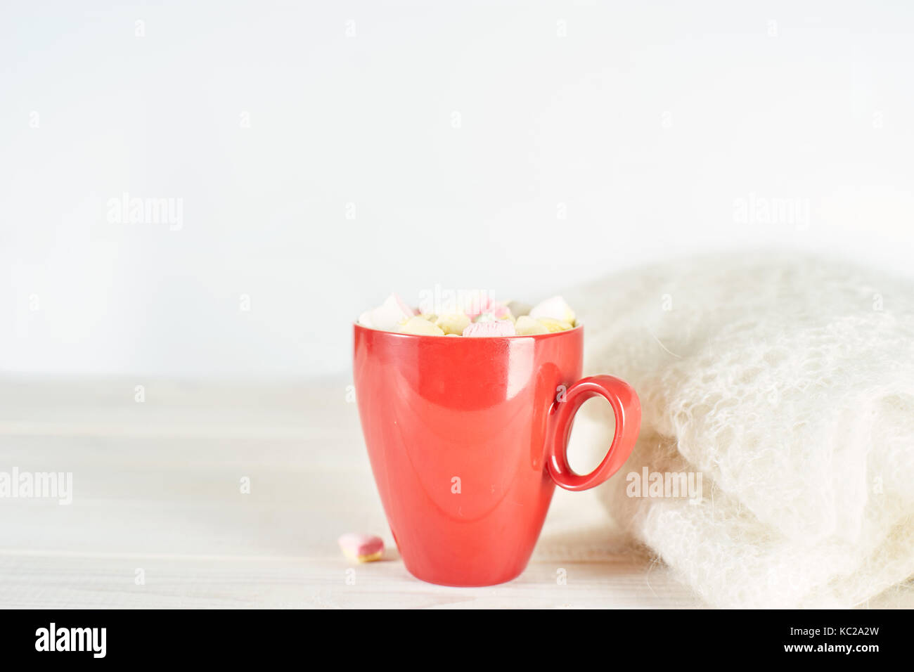 Rot Tasse Kaffee auf weiße Holztisch neben Strickwaren. kopieren. Stockfoto