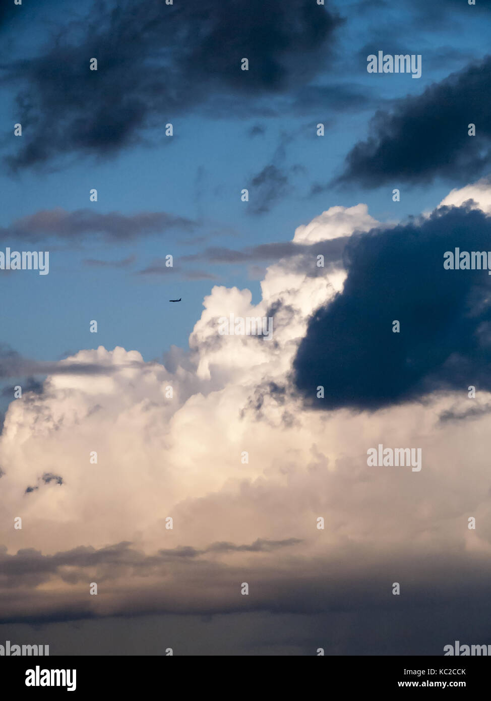 Silhouette eines Flugzeugs weg von einer schwarzen Wolke fliegen Stockfoto