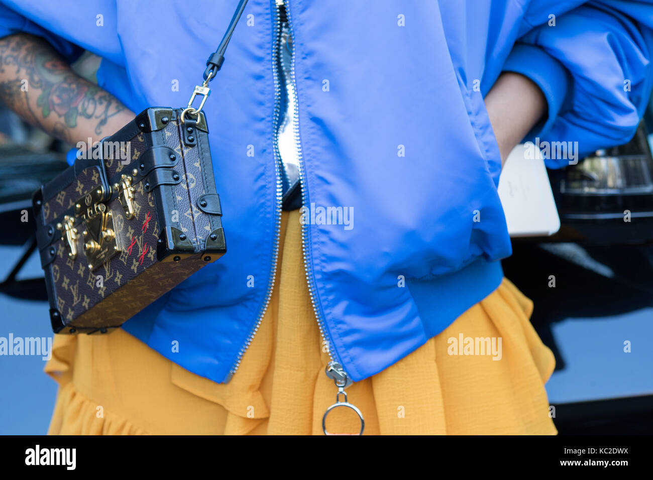 Mailand, Italien - 22. September 2017: Modell, das Tragen eines Orange langen Rock, eine blaue Jacke und eine Schultertasche während der armani Parade, fotografiert auf der Stockfoto