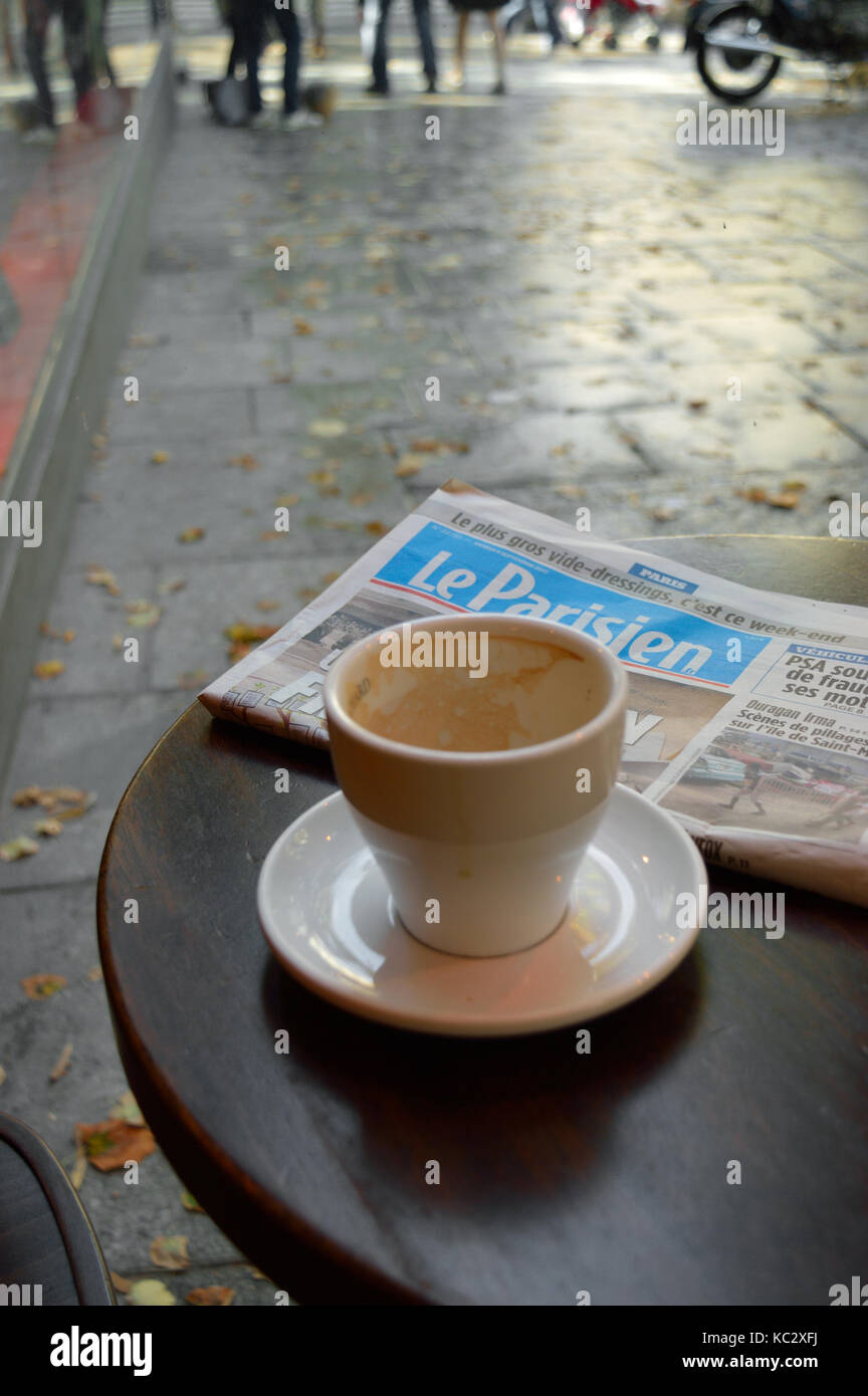 Paris, Frankreich - 9. September 2017: Eine leere Kaffeetasse und Le Parisien Zeitung auf dem cafe Tabelle. Stockfoto