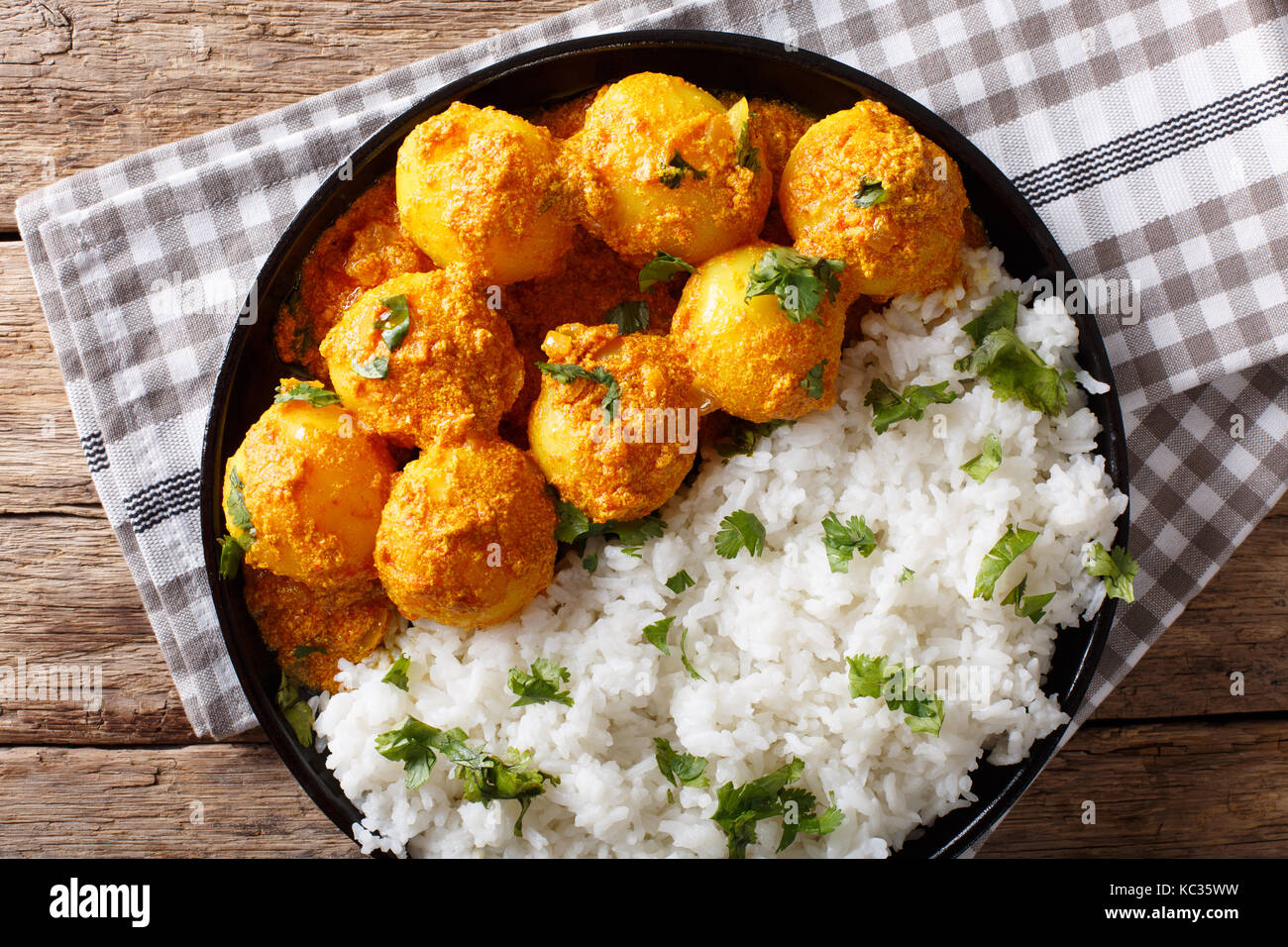 Indisches essen: Dum aloo Kartoffeln in Sauce mit Reis close-up auf einem Tisch. horizontal oben Ansicht von oben Stockfoto