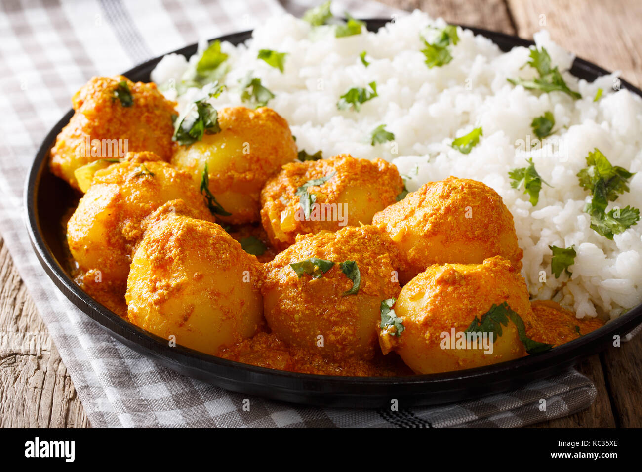 Indisches essen: Dum aloo Kartoffeln in Sauce mit Reis close-up auf einem Tisch. Horizontale Stockfoto
