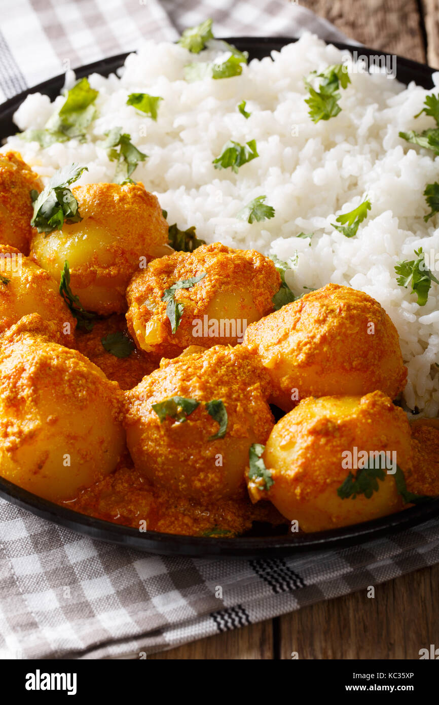 Indische Küche: Vegetarisch kashmiri Dum aloo Kartoffeln mit Reis close-up auf dem Tisch. Vertikale Stockfoto