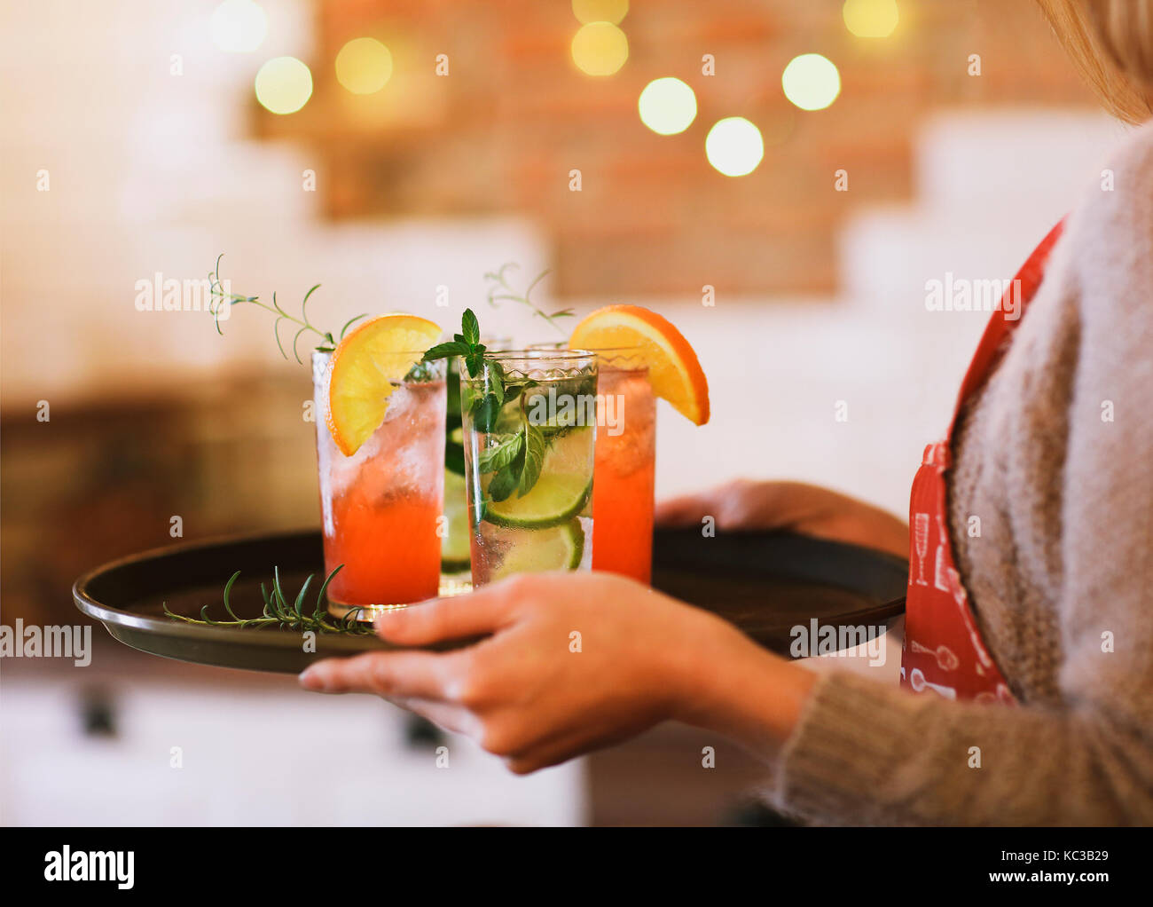Junge hübsche Frau mit roten und grünen Cocktails auf Fach in der Bar Stockfoto