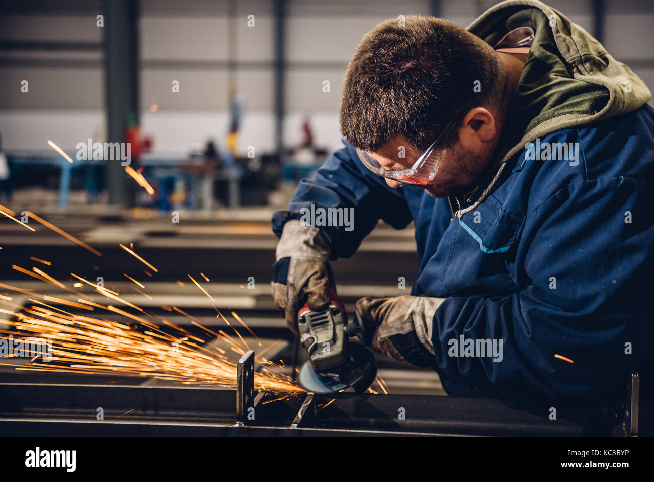 Arbeitnehmer mit Winkelschleifer in der Fabrik- und werfen Funken Stockfoto
