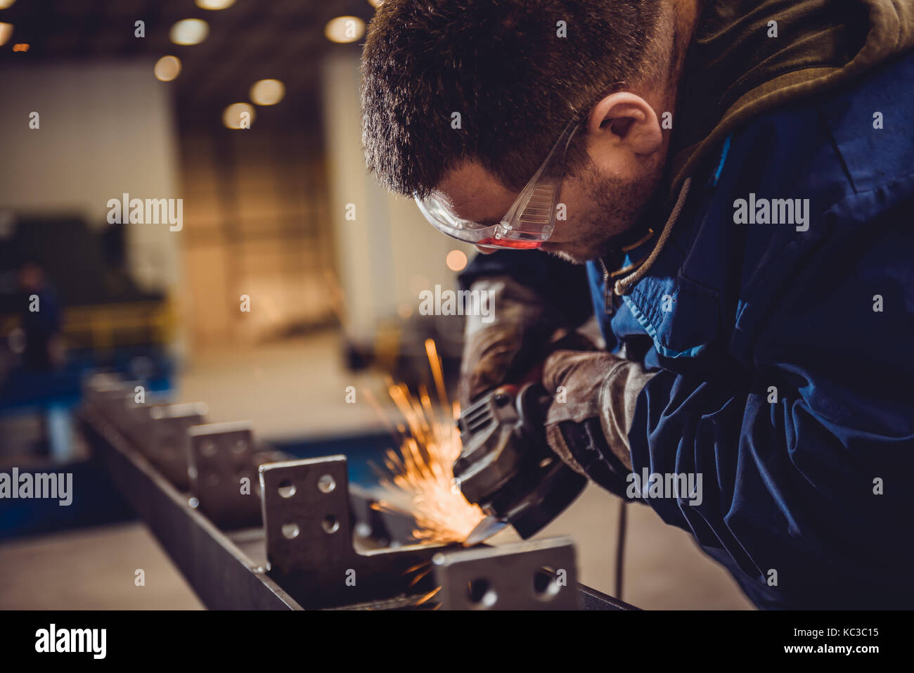 Arbeitnehmer mit Winkelschleifer in der Fabrik- und werfen Funken Stockfoto