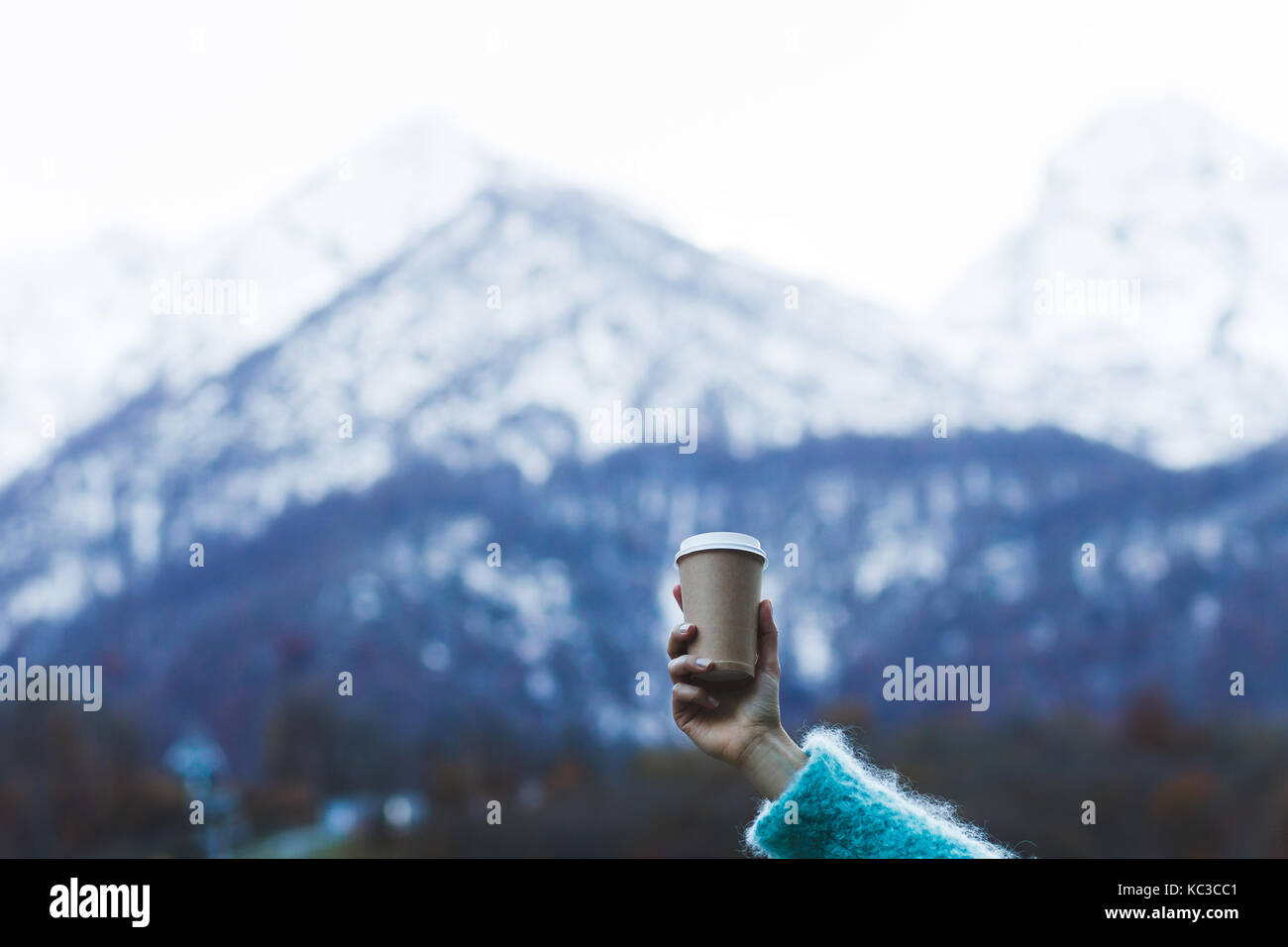 Girl's Hand halten einer Tasse wärmenden Getränk mit Blick auf die Berge Stockfoto