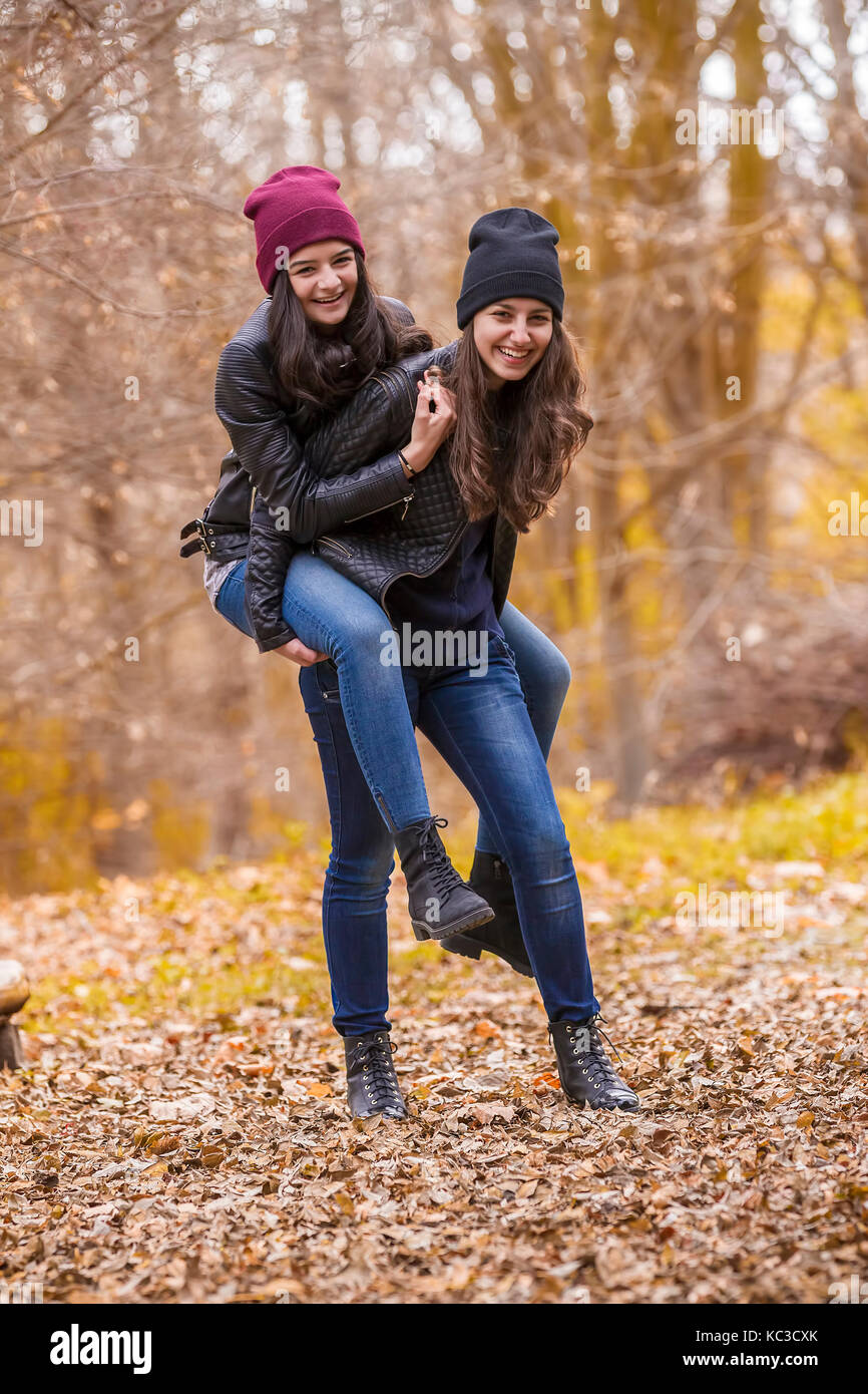Zwei lachende Mädchen spielen im Freien im Herbst Park Stockfoto