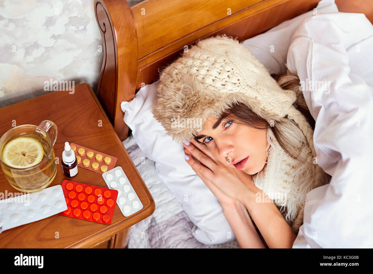 Kranke junge Frau auf dem Bett im Zimmer Stockfoto