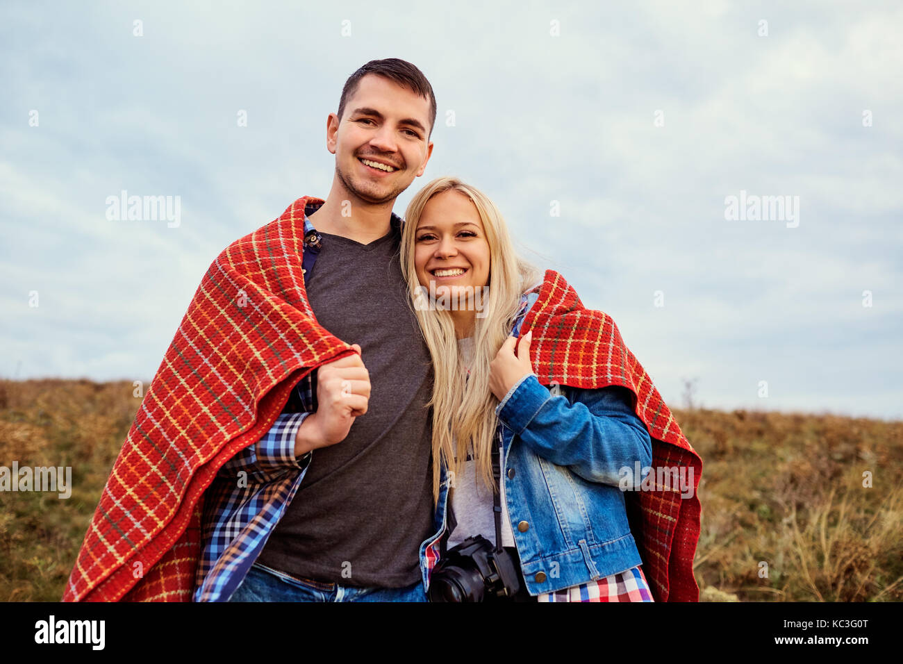 Glückliches Paar unter einem Plaid im Freien. Stockfoto