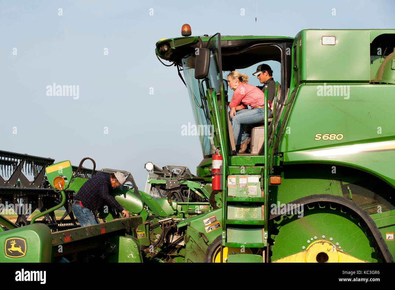 Eine junge weibliche Landwirt Gespräche mit angestellt, um die Hände vor der überschrift heraus zum Ernten von Weizen auf der Farm der Familie in Breckenridge, Colorado, wo sie wachsen 1. Stockfoto