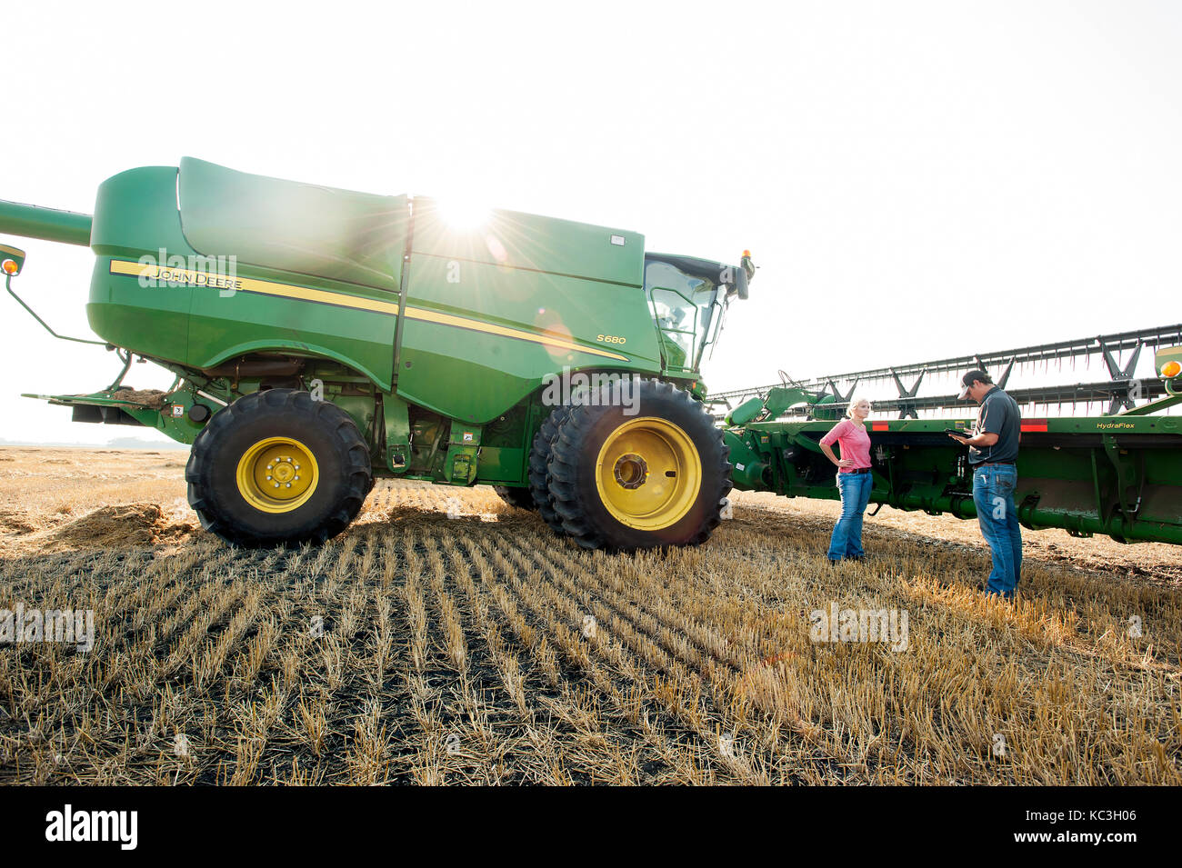 Eine junge weibliche Landwirt Gespräche mit einem GPS-Spezialist, vor der überschrift zum Ernten von Weizen auf der Farm der Familie in Breckenridge, Colorado, wo Sie Stockfoto