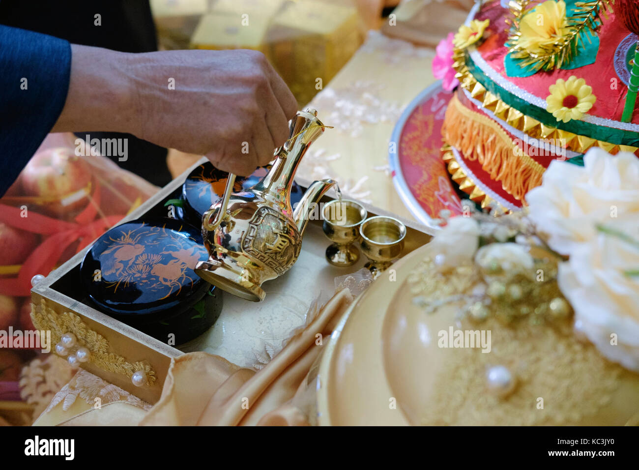 Hände sind gießt Gläser Wein, ein Verfahren in der traditionellen Hochzeit in Vietnam. Stockfoto