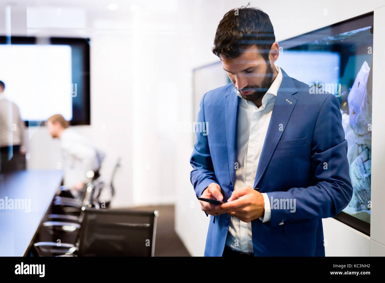 Portrait der junge Geschäftsmann mit Mobiltelefon Stockfoto