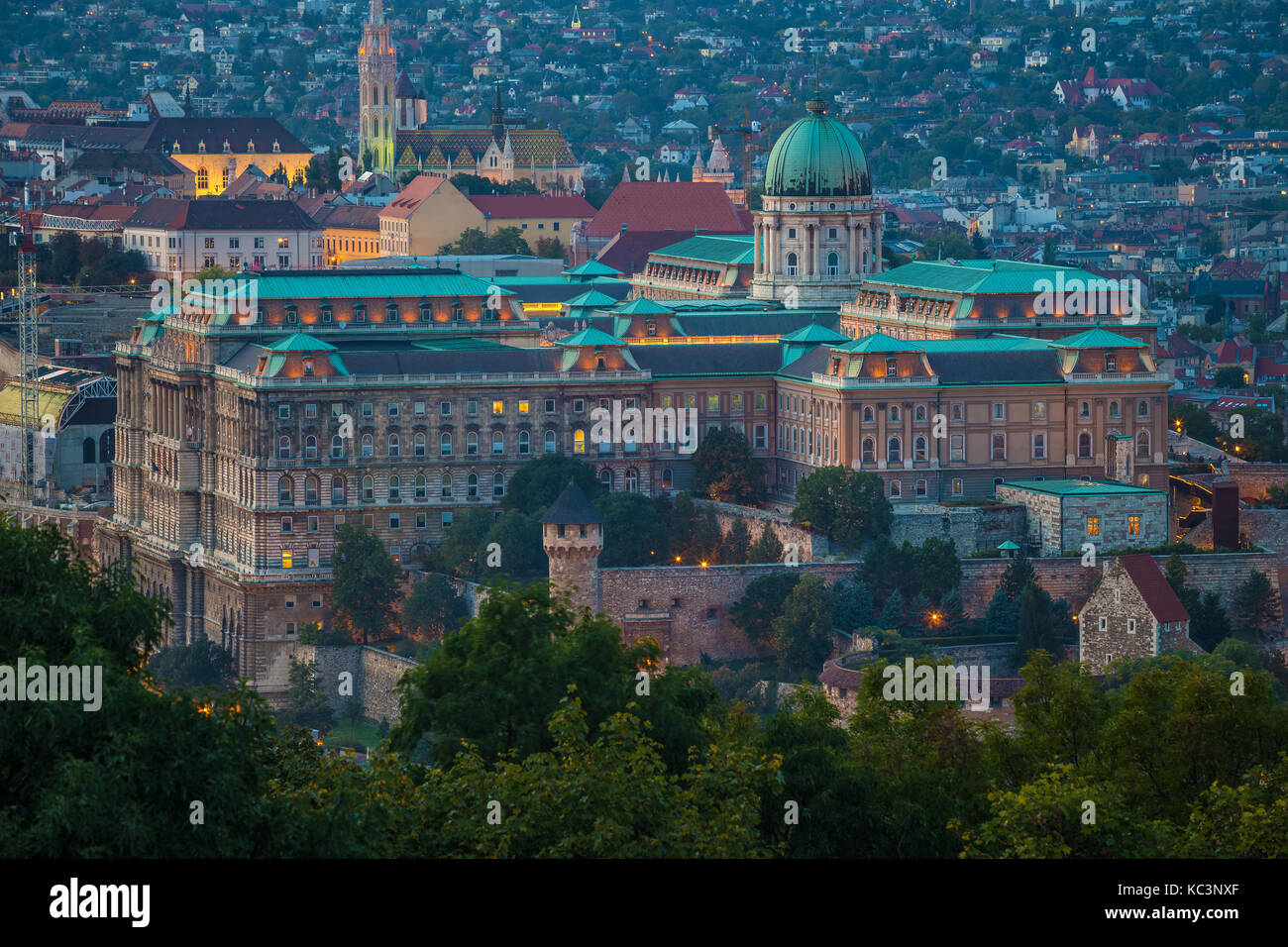 Budapest, Ungarn - Der schöne Königspalast der Buda-Burg mit den Buda-Hügeln und der Matthias Kirche im Hintergrund zur Zauberstunde Stockfoto