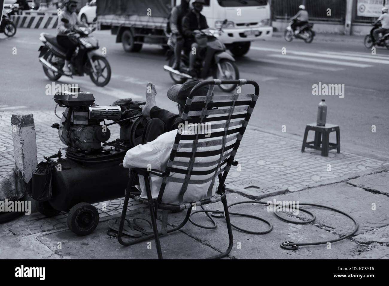 Der alte Mann Reparatur Fahrrad in der Mitte der Straße. Stockfoto