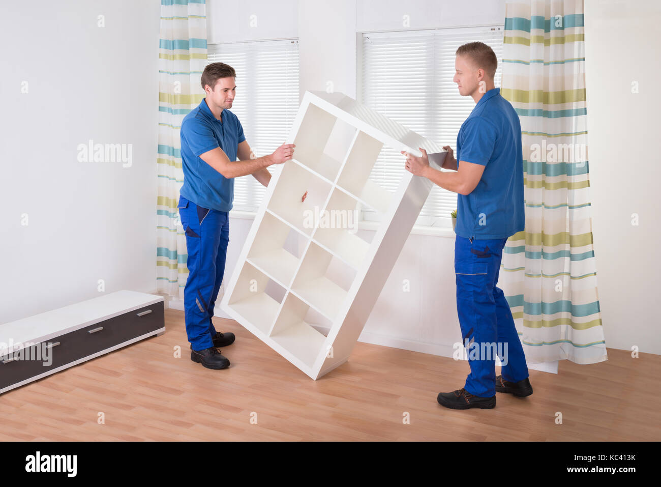 Junge männliche movers Regal zu Hause tragen Stockfoto