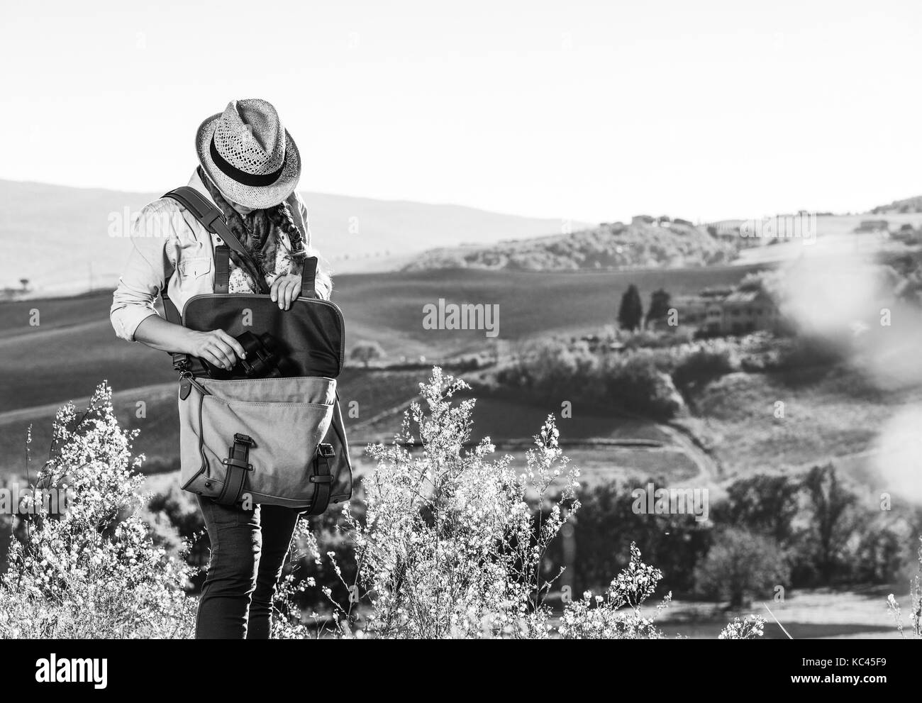 Entdecken Sie magische Ausblicke der Toskana. junge Frau Wanderer mit Tasche wandern in der Toskana Fernglas nehmen Stockfoto