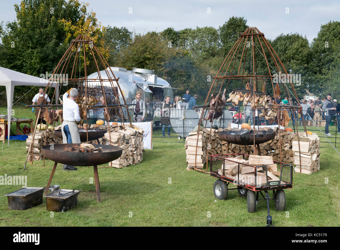 Im Freien kochen Hühner- und Schweinefleisch bei Daylesford Organic Farm Herbstfest. Daylesford, Cotswolds, Gloucestershire, England Stockfoto