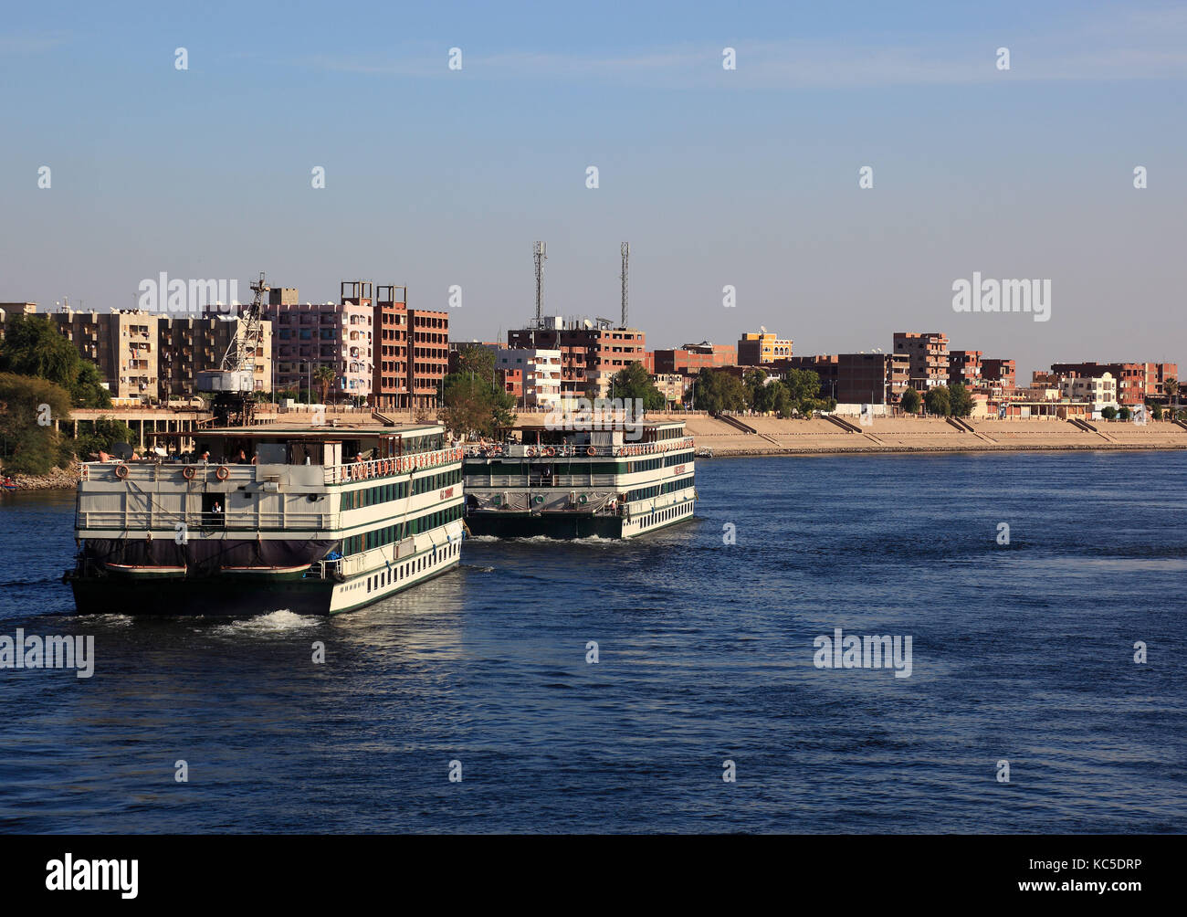 Kreuzfahrtschiffe in der Nähe von Dorf von Kom Ombo auf dem Nil, Ägypten Stockfoto