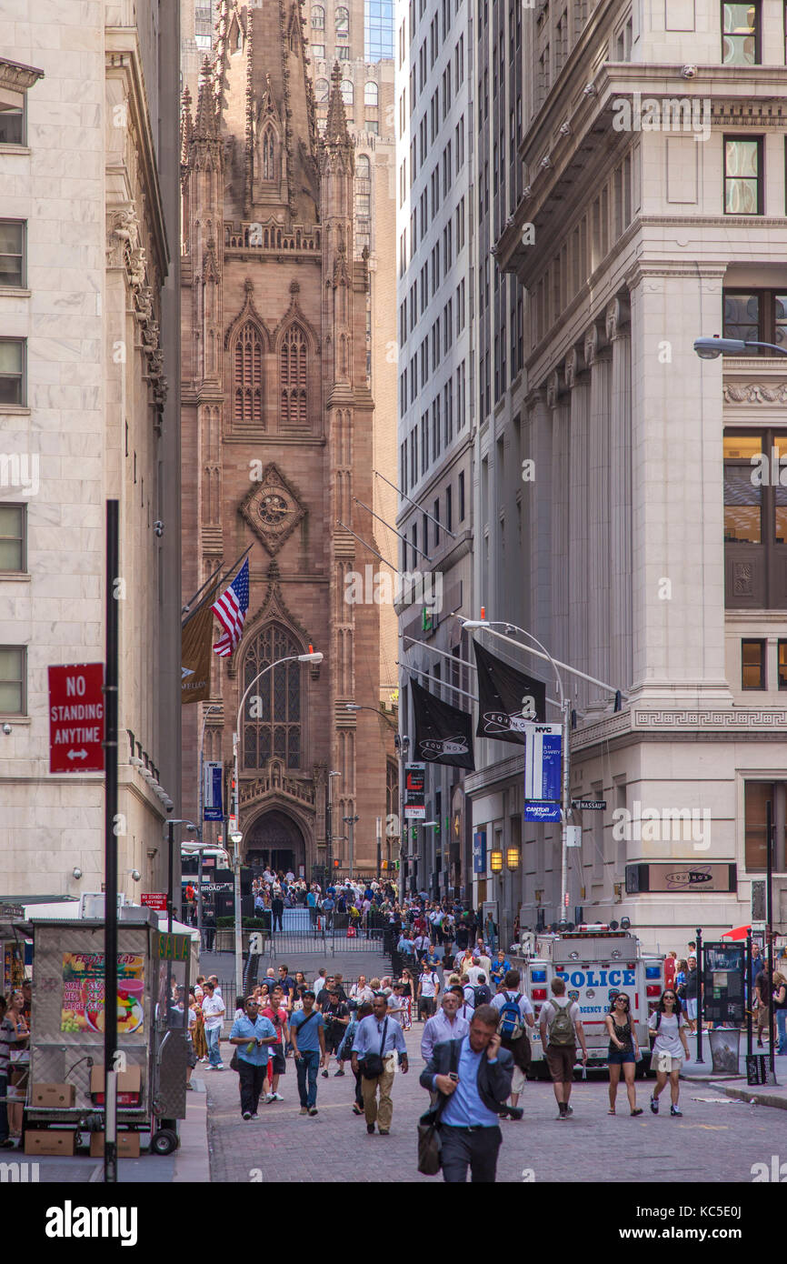 Touristen und Geschäftsleute gehen Sie die Wall Street mit der Trinity Church, New York City, USA Stockfoto