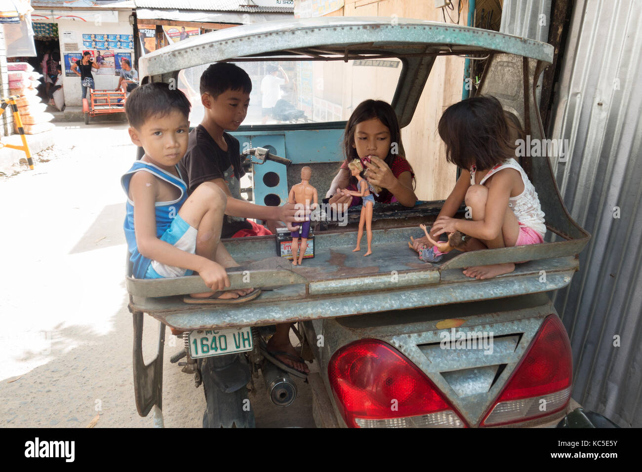 Philippinischen Kindern spielt mit Puppen in der Rückseite eines Taxi, Cebu City, Cebu, Philippinen Stockfoto