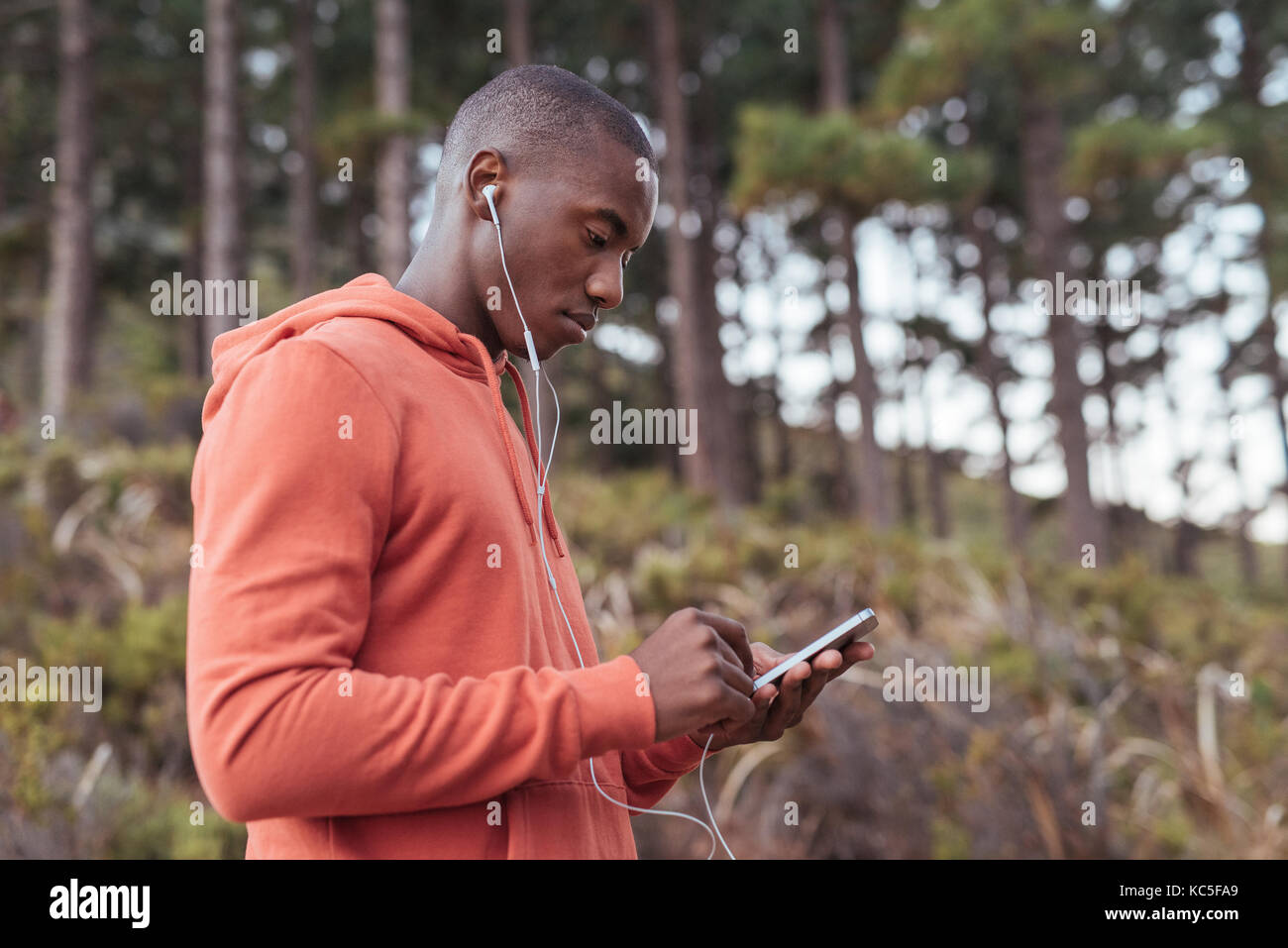Passen junge afrikanische Menschen Musik hören vor einem Lauf Stockfoto