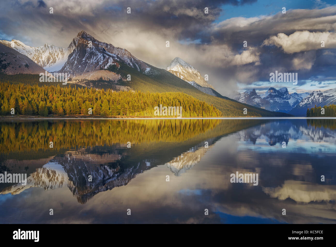 Berg und seine Reflexion Zeichnung als Pfeil in Maligne Lake mit dramatischen bewölkten Himmel. Kanada Landschaft. Spiegelbild. Stockfoto