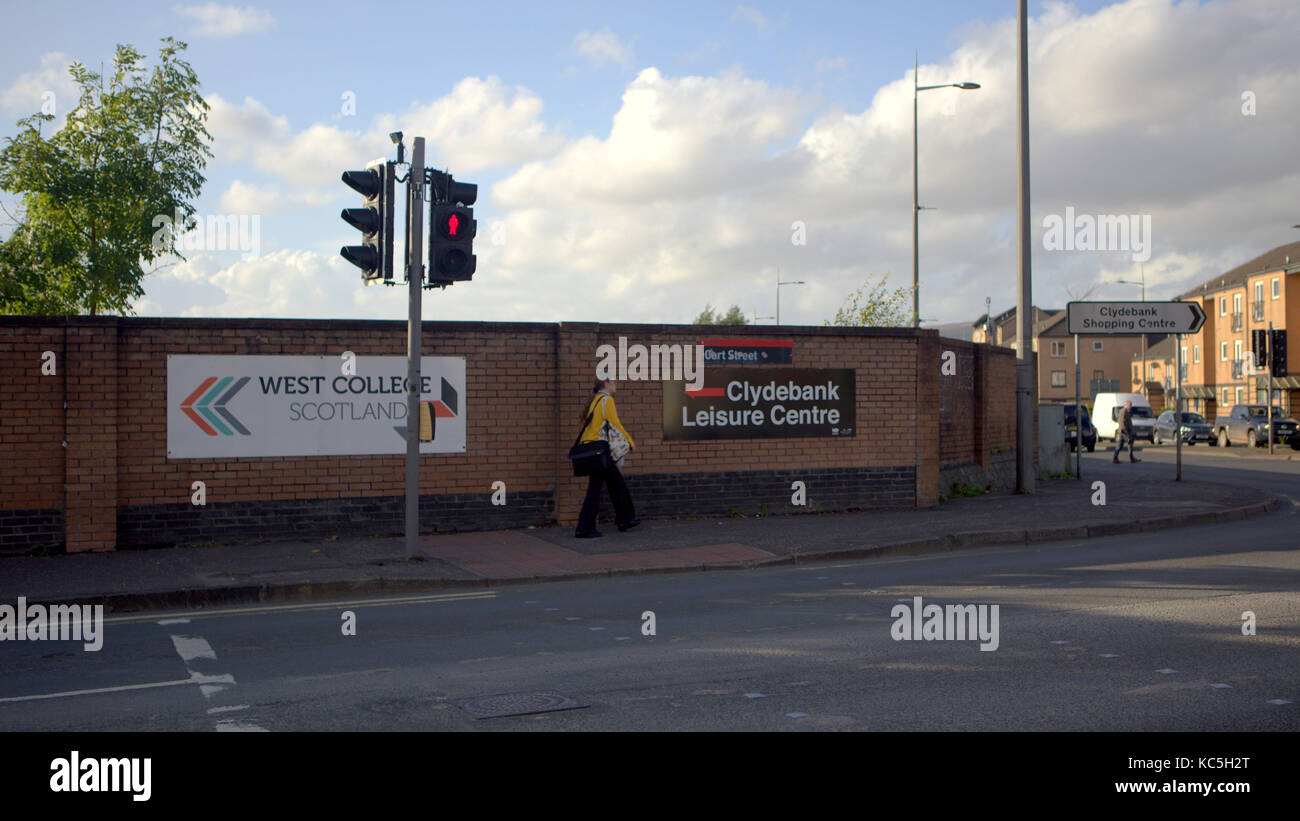 Frau in der Nähe von Ampeln und Schildern zum Gehen auf der Straße Clydebank, Großbritannien Stockfoto