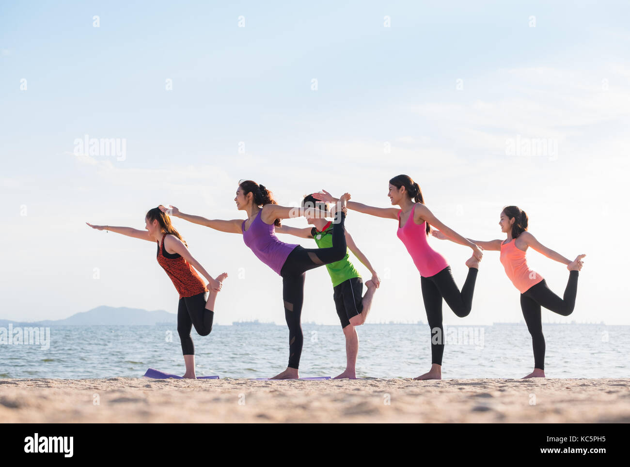 Yoga am Meer Strand am Abend, eine Gruppe von Leuten, die Herrn der Tanz wirft mit Clam emotion am Strand entspannen, Meditation, Wellness und Gesundheit Stockfoto