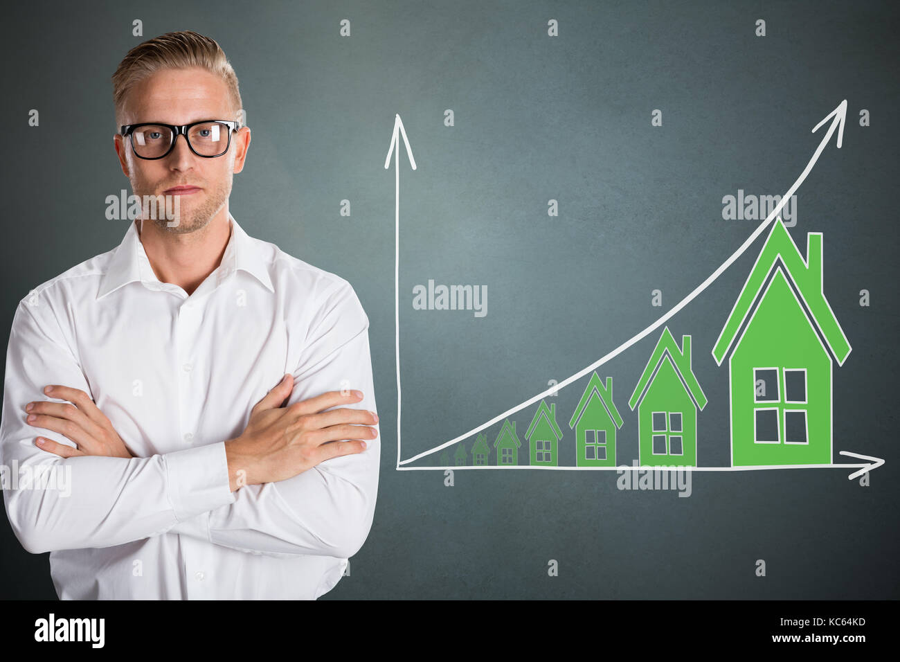 Junge zuversichtlich Geschäftsmann mit Immobilien Konzept Über grauer Hintergrund Stockfoto Junge zuversichtlich Geschäftsmann mit Immobilien Konzept Über grauer Hintergrund Stockfoto
