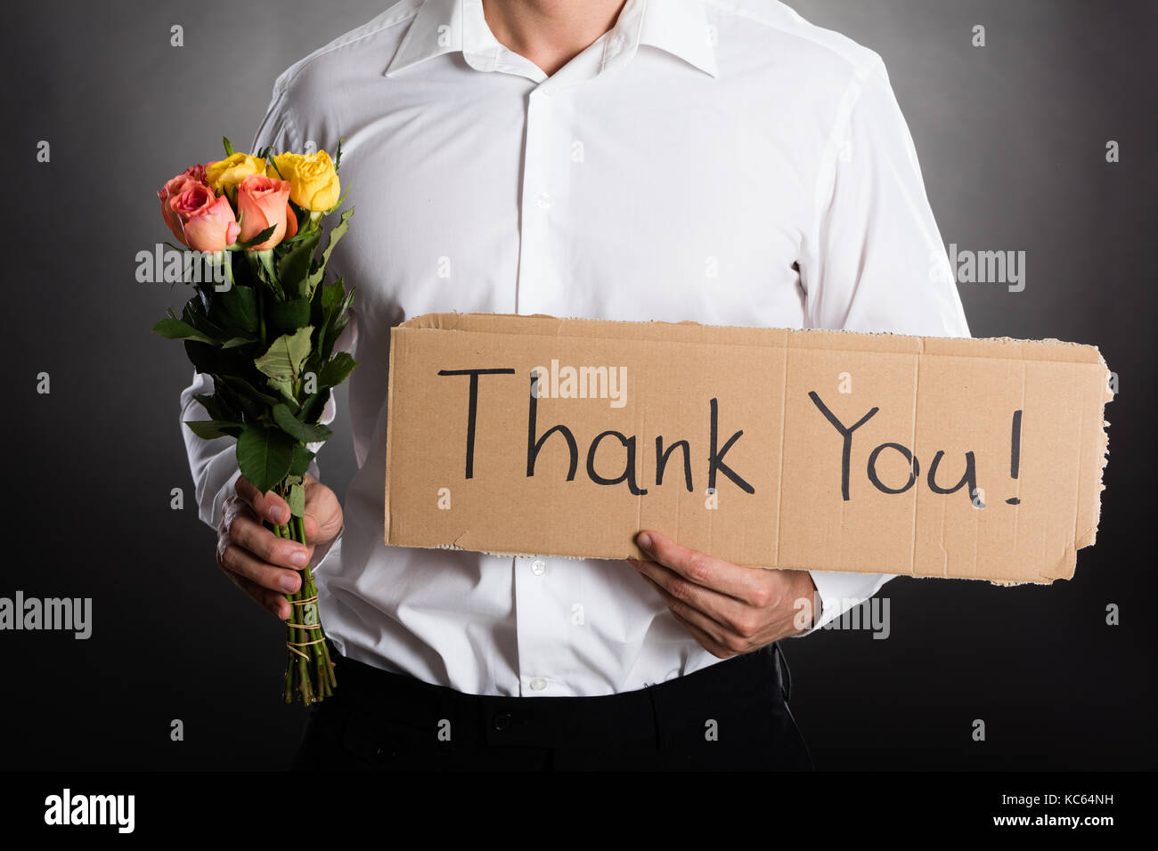Mann mit Rosen und vielen Dank Text auf Karton gegen grauen Hintergrund  geschrieben Stockfotografie - Alamy