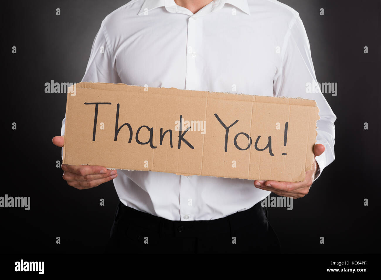 Nahaufnahme der Mann mit Pappe mit vielen Dank Text auf schwarzem Hintergrund Stockfoto