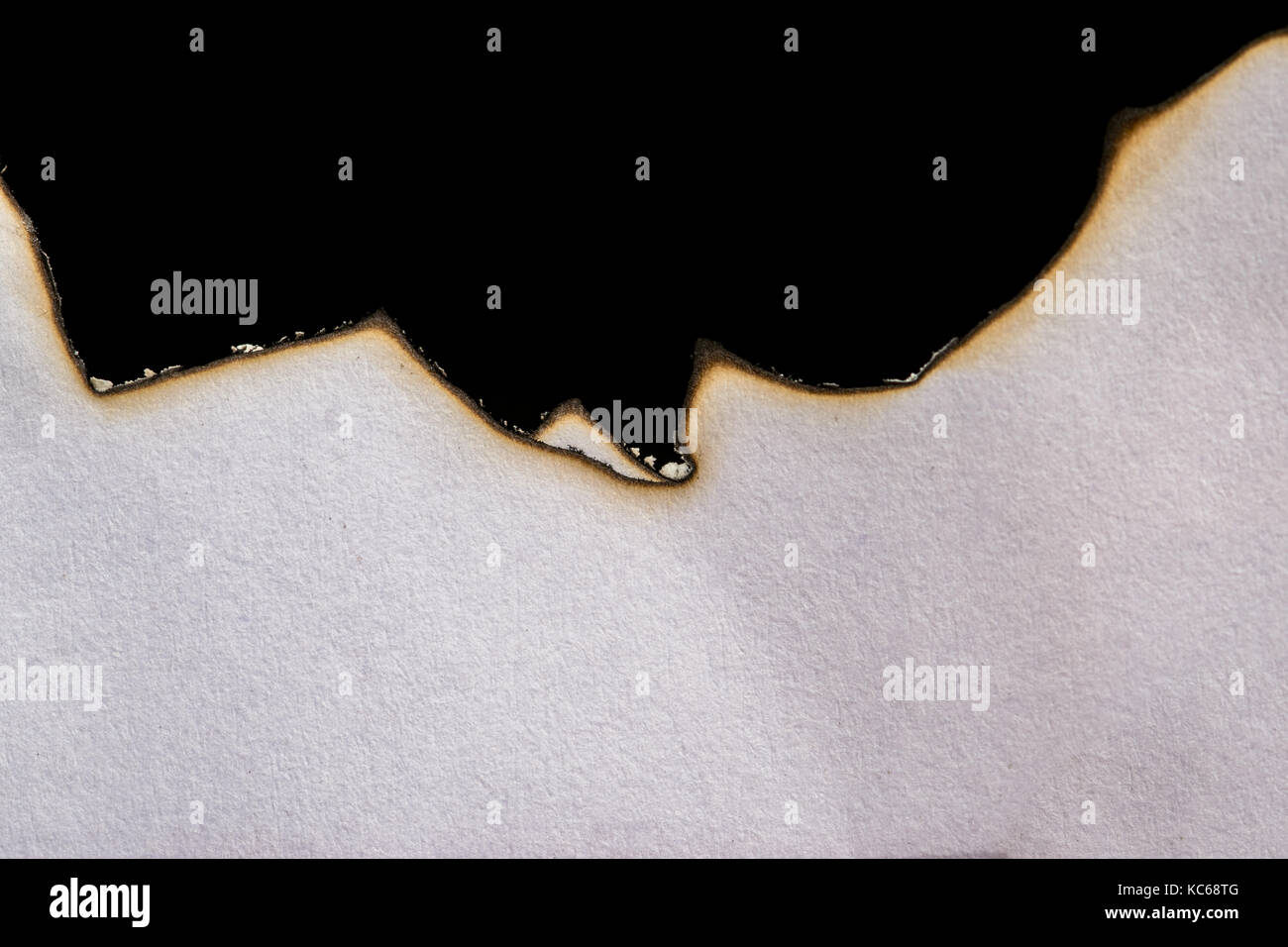 Verbrannt, verbrannt und verkohlt Weißbuch auf schwarzem Hintergrund, Asche und Linien brennen Stockfoto