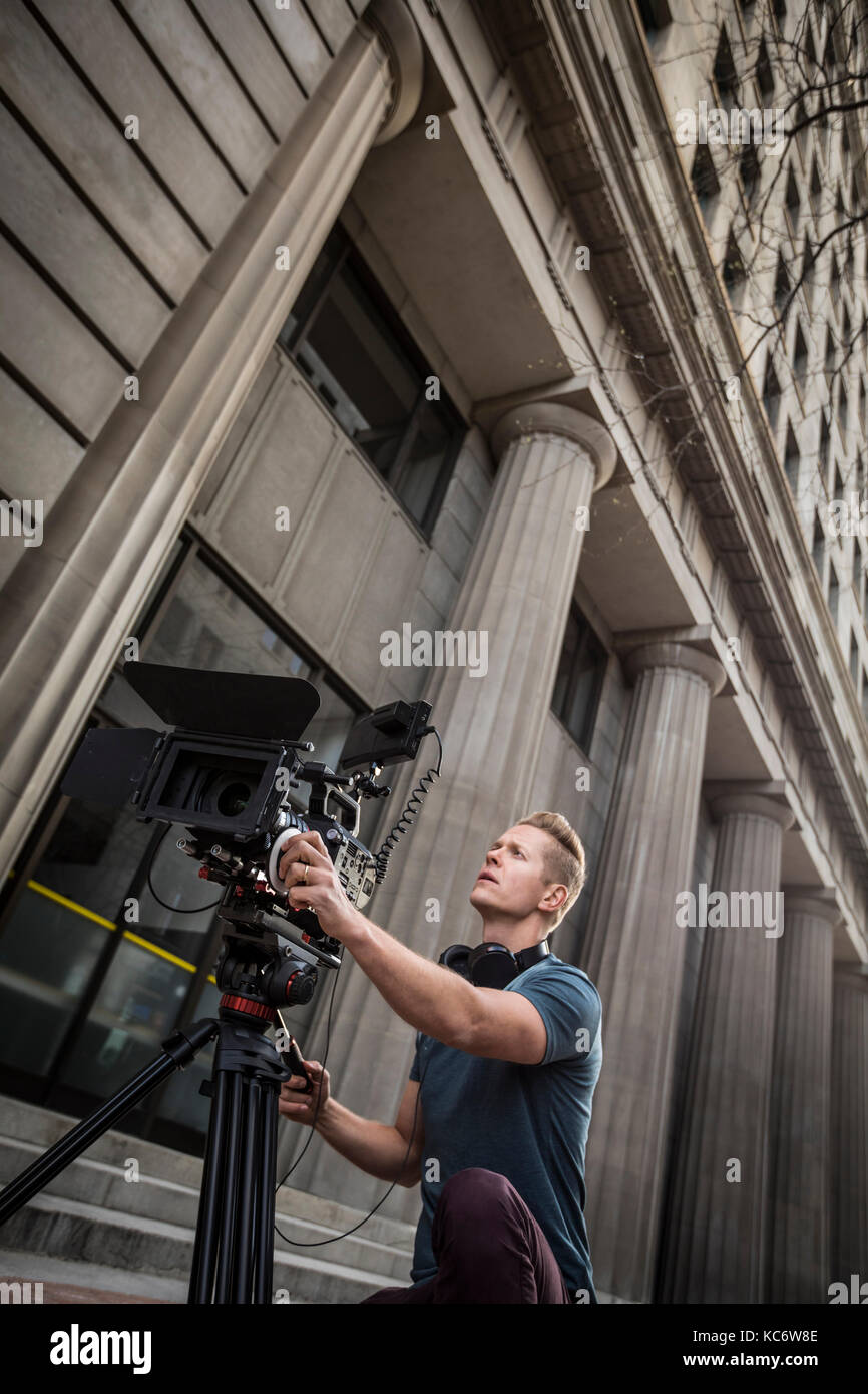Bediener der Kamera Filmen vor Gebäude Stockfoto