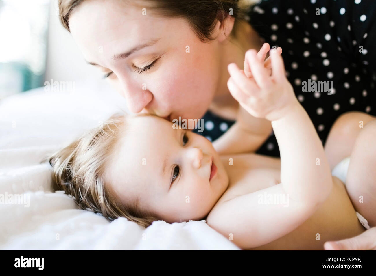 Baby (6-11 Monate) von der Mutter geküsst zu werden Stockfoto