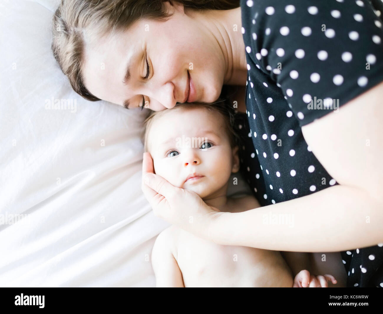 Baby (6-11 Monate) umarmt von Mutter, direkt über Stockfoto