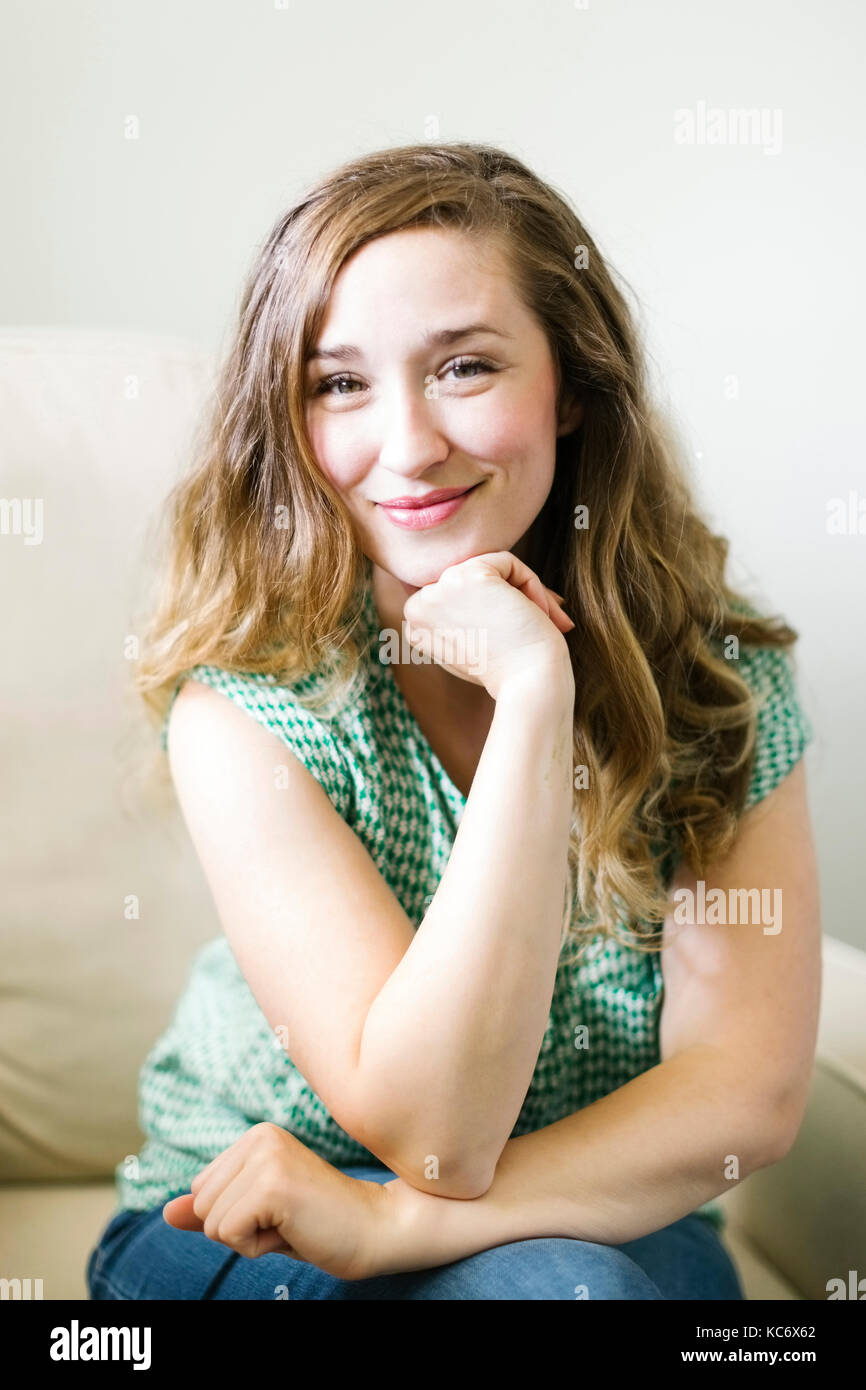 Portrait von Frau im Wohnzimmer sitzen Stockfoto