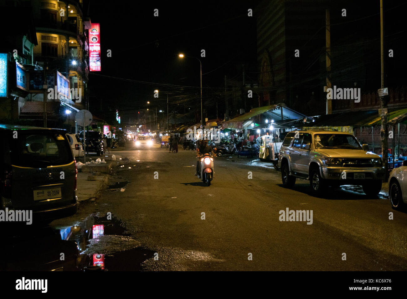Straße in Phnom Penh, parallel zur Siswath Kai - Riverfront. Straße hat keinen Bürgersteig, Motorräder schmutzig und Straßenhändler auf einer Seite. Kambodscha Südostasien Stockfoto