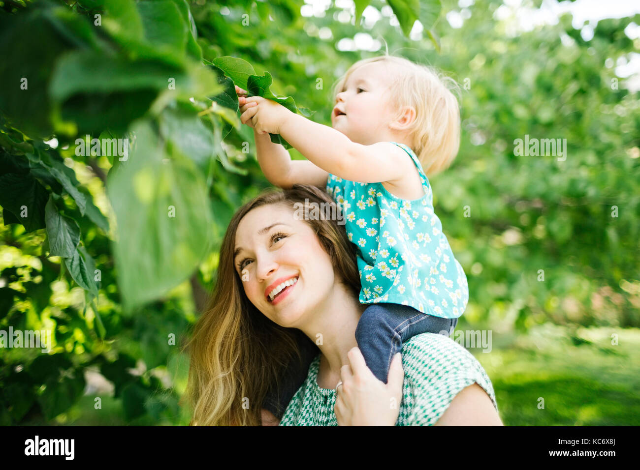 Mutter mit Tochter (12-17 Monate) auf den Schultern Stockfoto