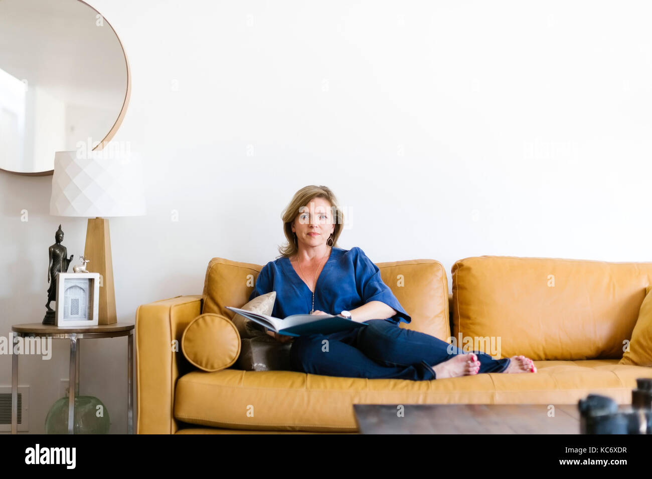 Frau sitzt auf einem Sofa im Wohnzimmer. Stockfoto