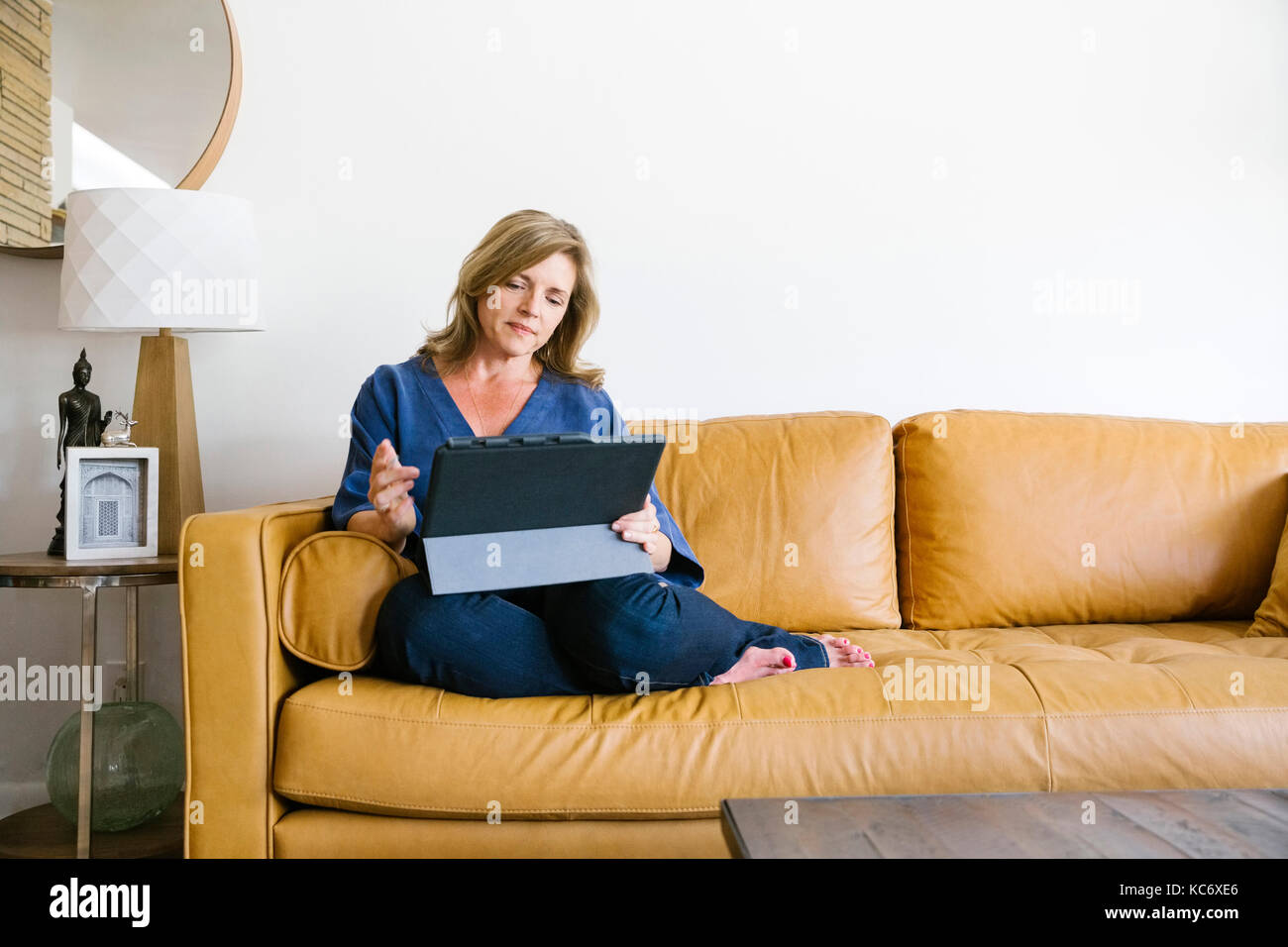 Frau mit digitalen Tablet auf dem Sofa Stockfoto