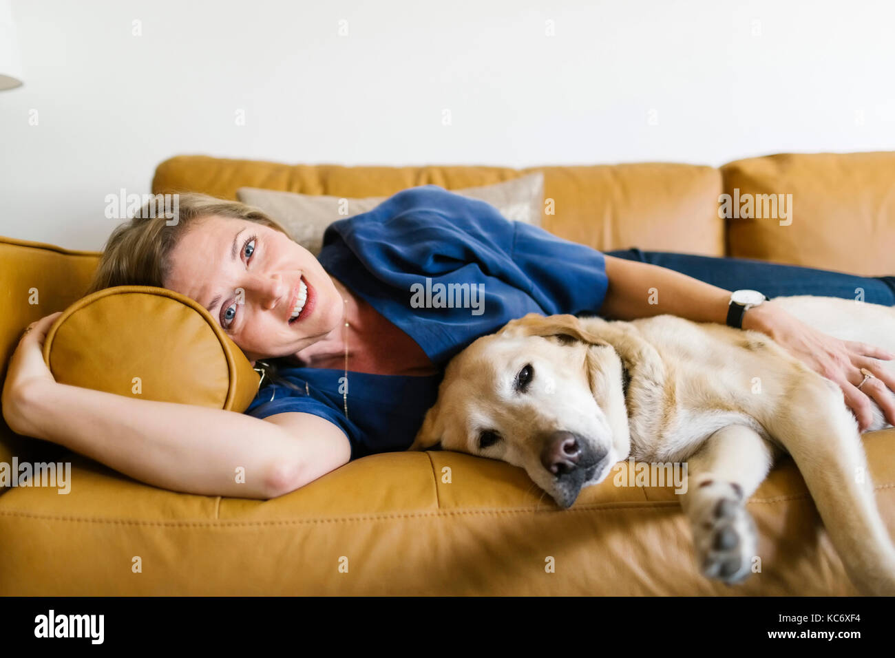 Frau und Labrador Retriever liegend auf dem Sofa Stockfoto