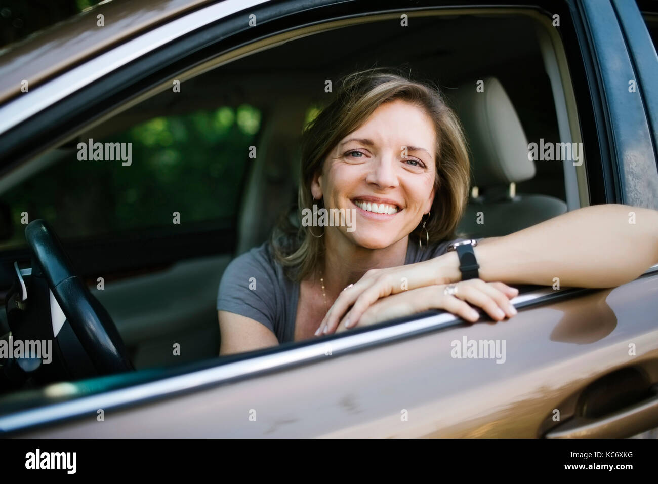 Porträt der lächelnde Frau Blick durch Fenster Stockfoto