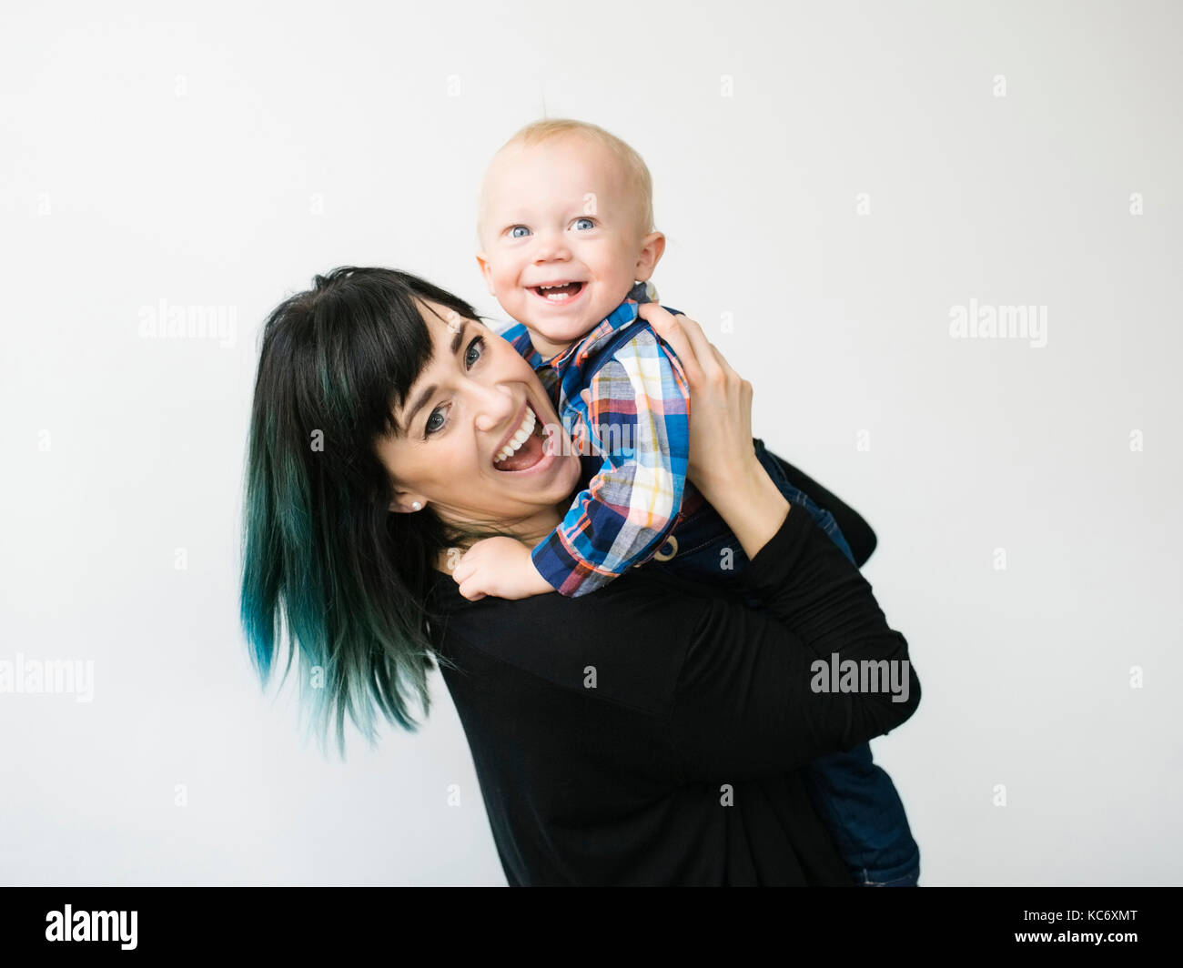 Porträt der Mutter mit Sohn (12-17 Monate) vor weißem Hintergrund Stockfoto