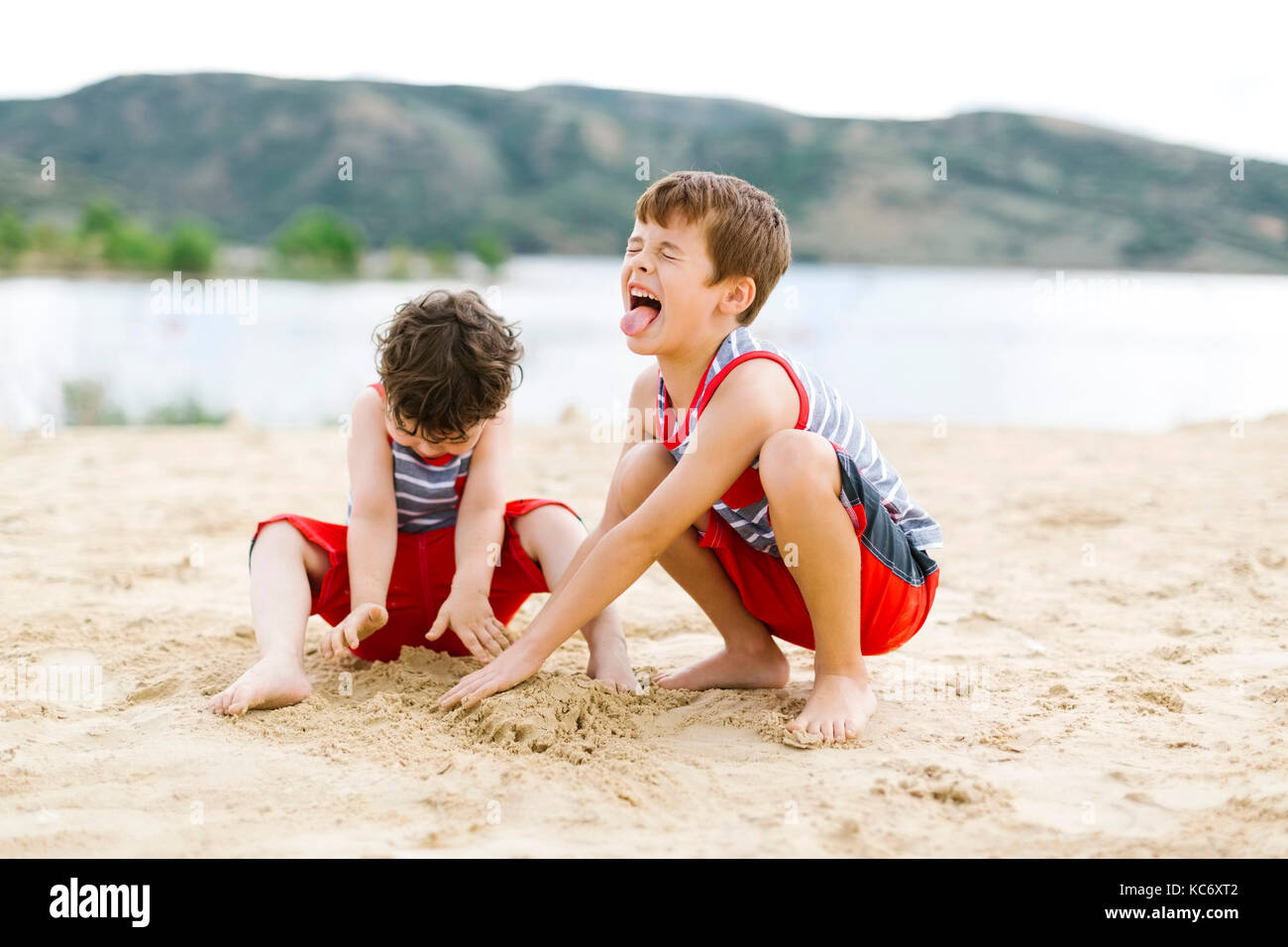 Brüder (4-5, 6-7) spielen am Strand von See Stockfoto