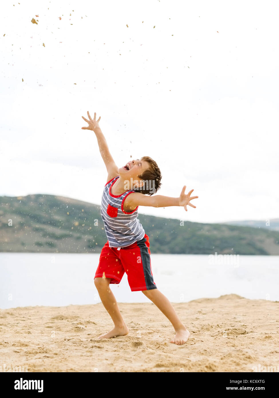 Junge (6-7) beim Spielen am Strand von See Stockfoto