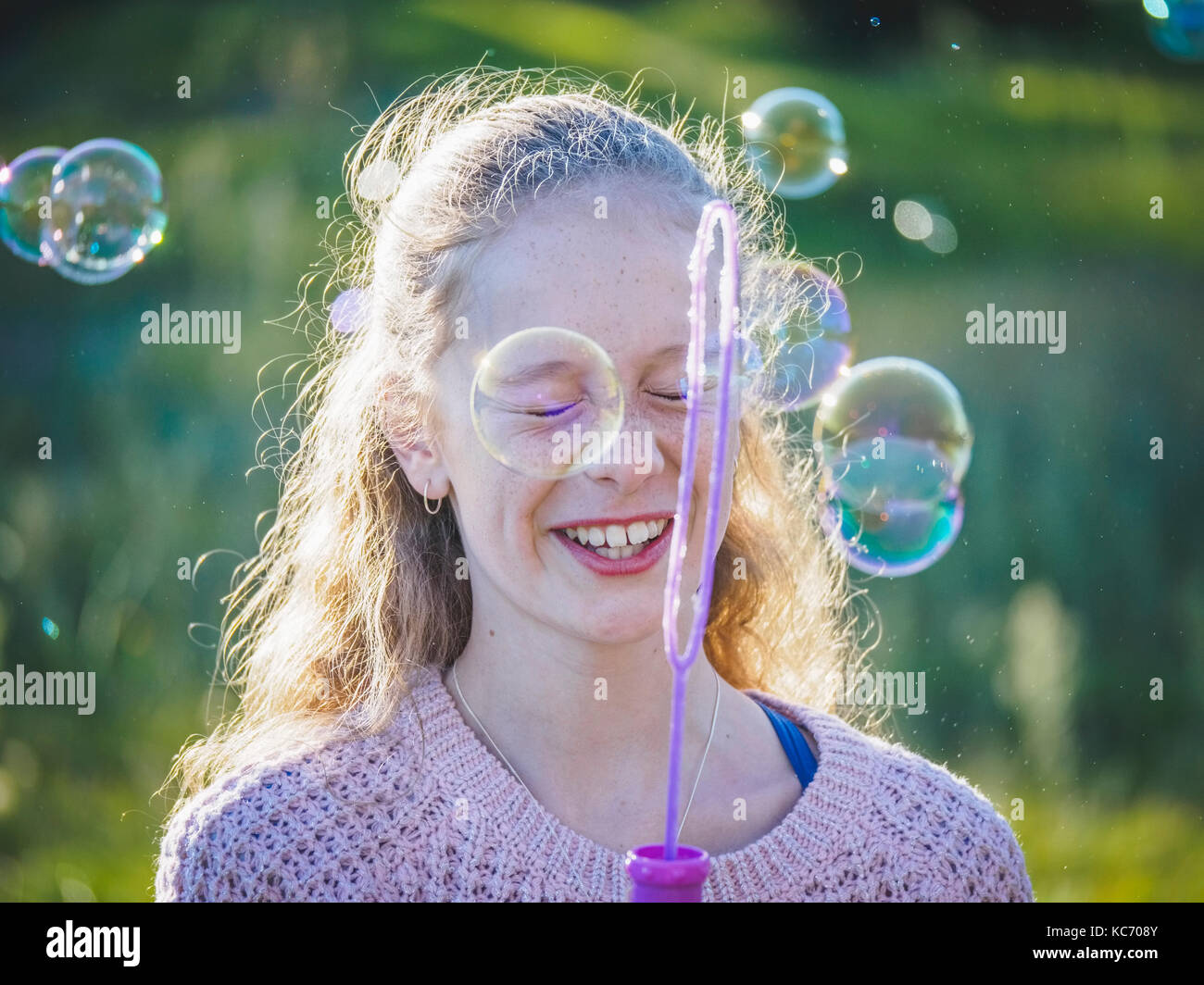 Mädchen (12-13) bläst Seifenblasen Stockfoto