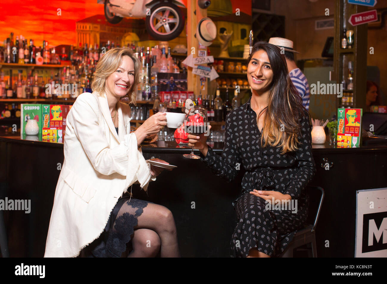 Tausendjährige und eine midlifer swapping Trinkgewohnheiten in einer lokalen Bar in London, Großbritannien Stockfoto